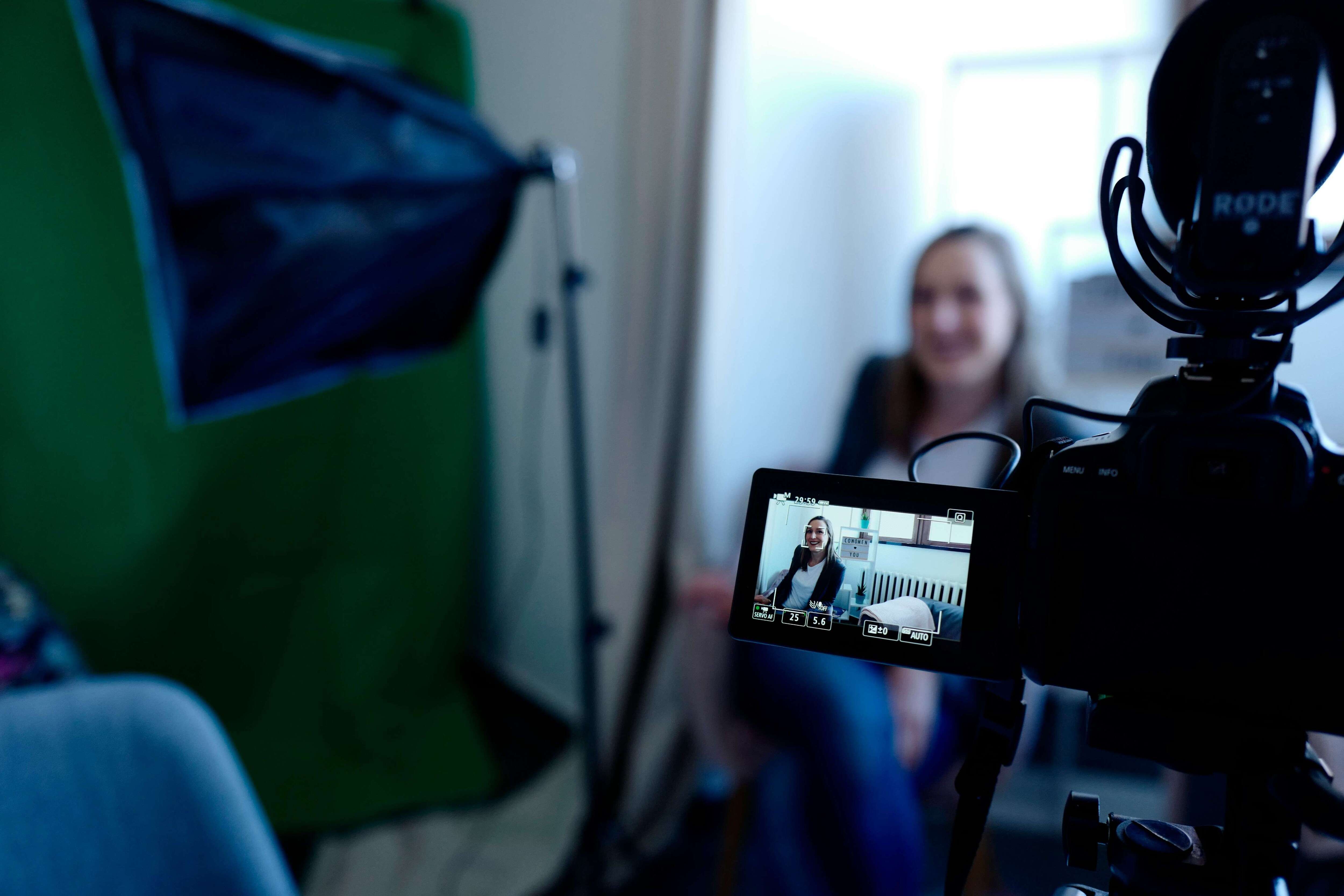 woman using a camera to record async interview 