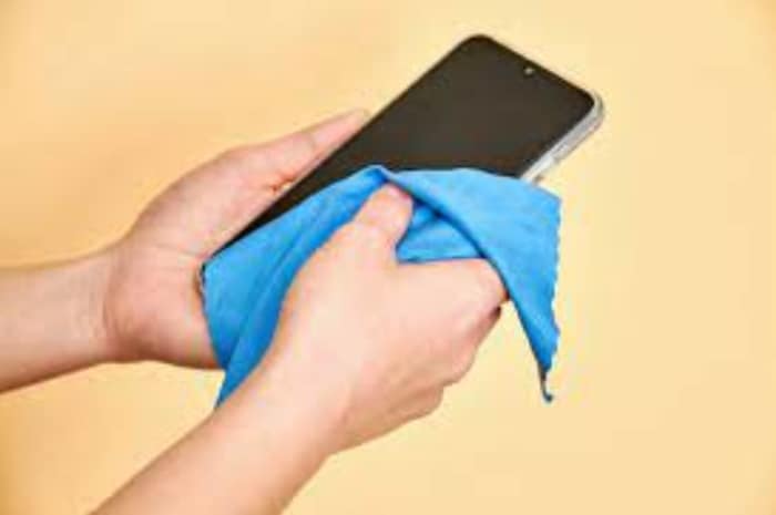 wiping phone screen with clean cloth