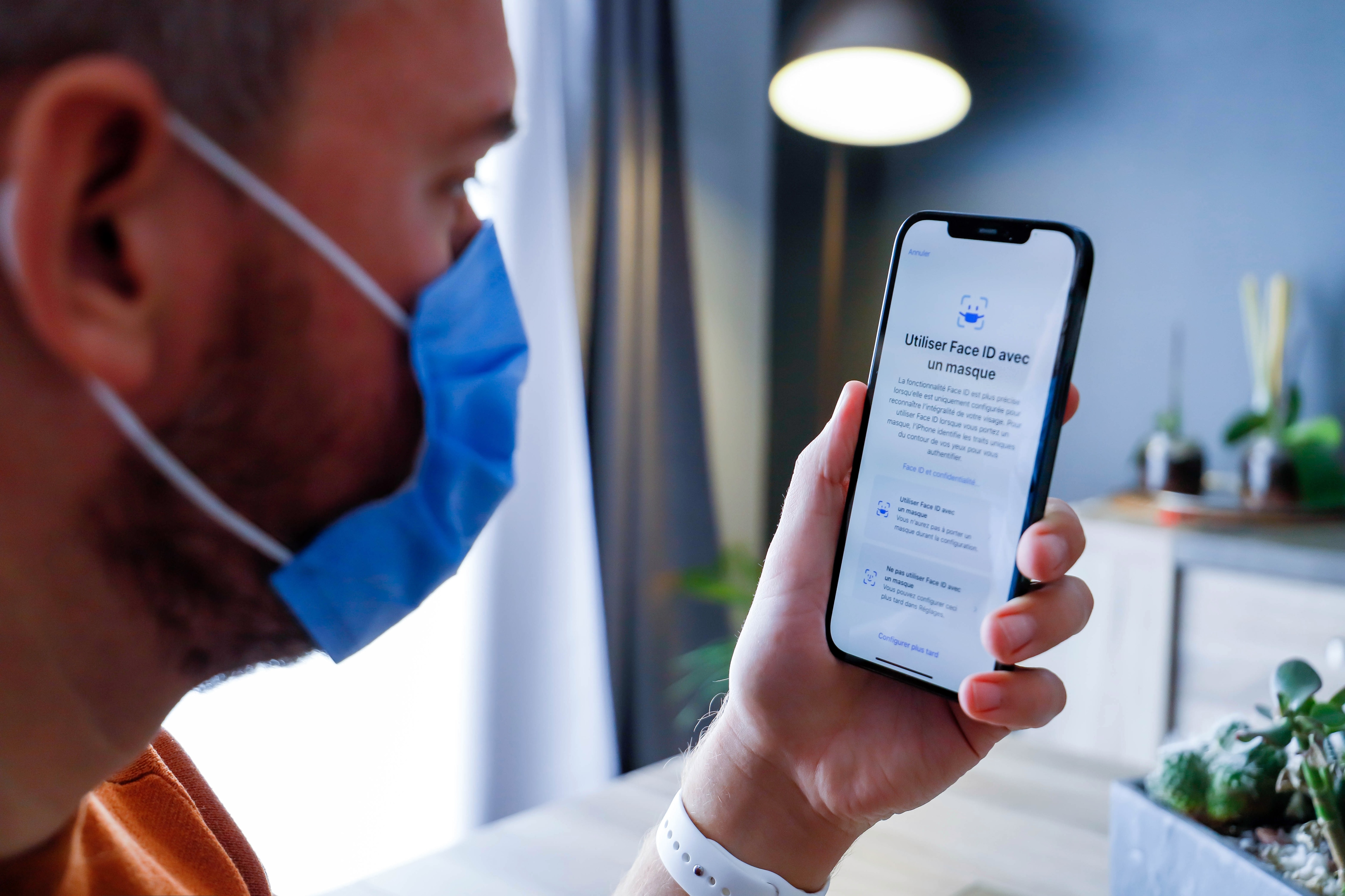 person wearing face mask unlocking their iphone