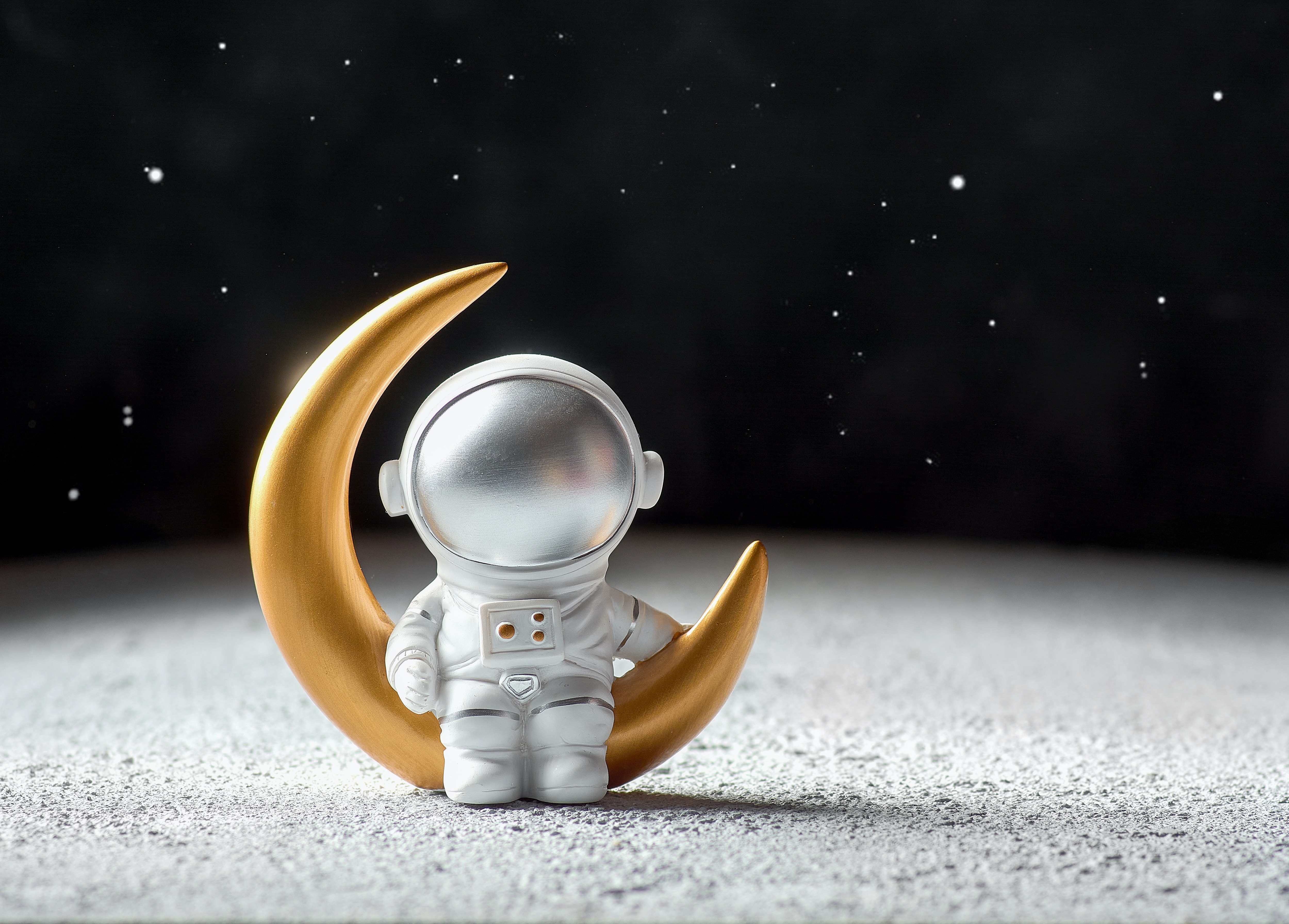 Immagine generata dall'intelligenza artificiale di un astronauta giocattolo seduto su una falce di luna