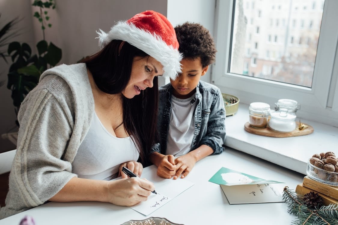 Madre e hijo escribiendo mensaje de Navidad