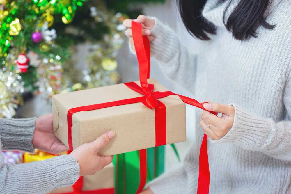 Mujer abriendo un regalo de navidad