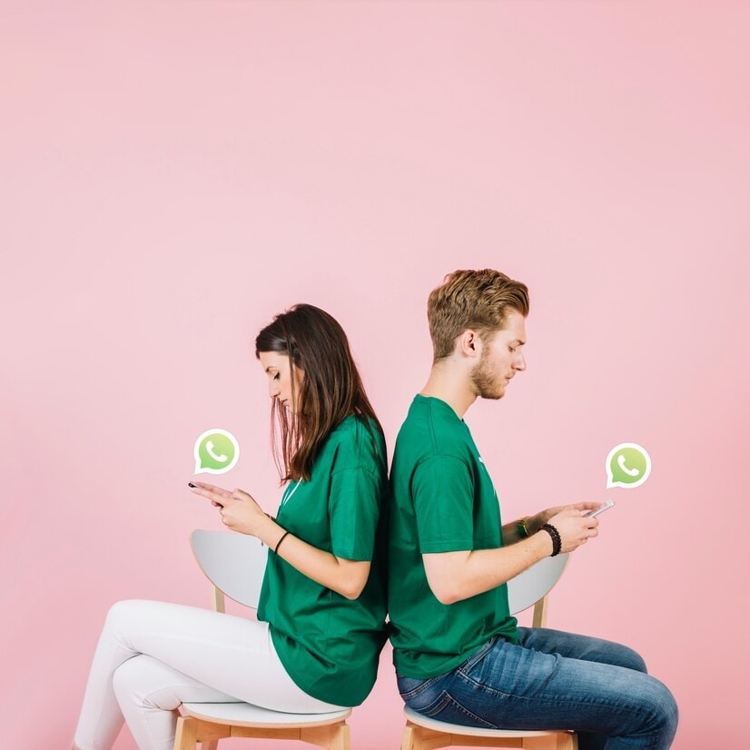 couple sitting back using whatsapp