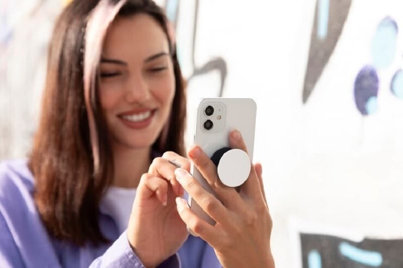 woman smiling while using iphone