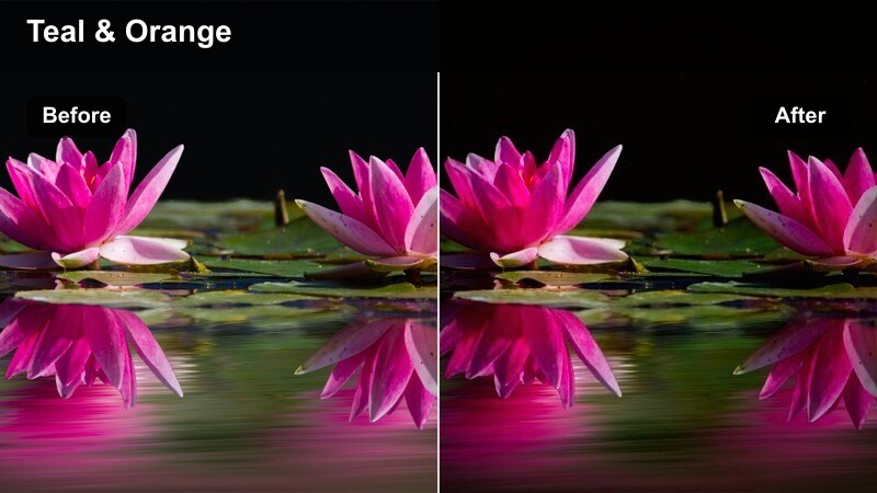 Skateboarder passing under teal-toned streetlights in a downtown area at night.