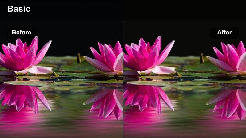 Two people talking on a rooftop at blue hour with a city skyline behind them.