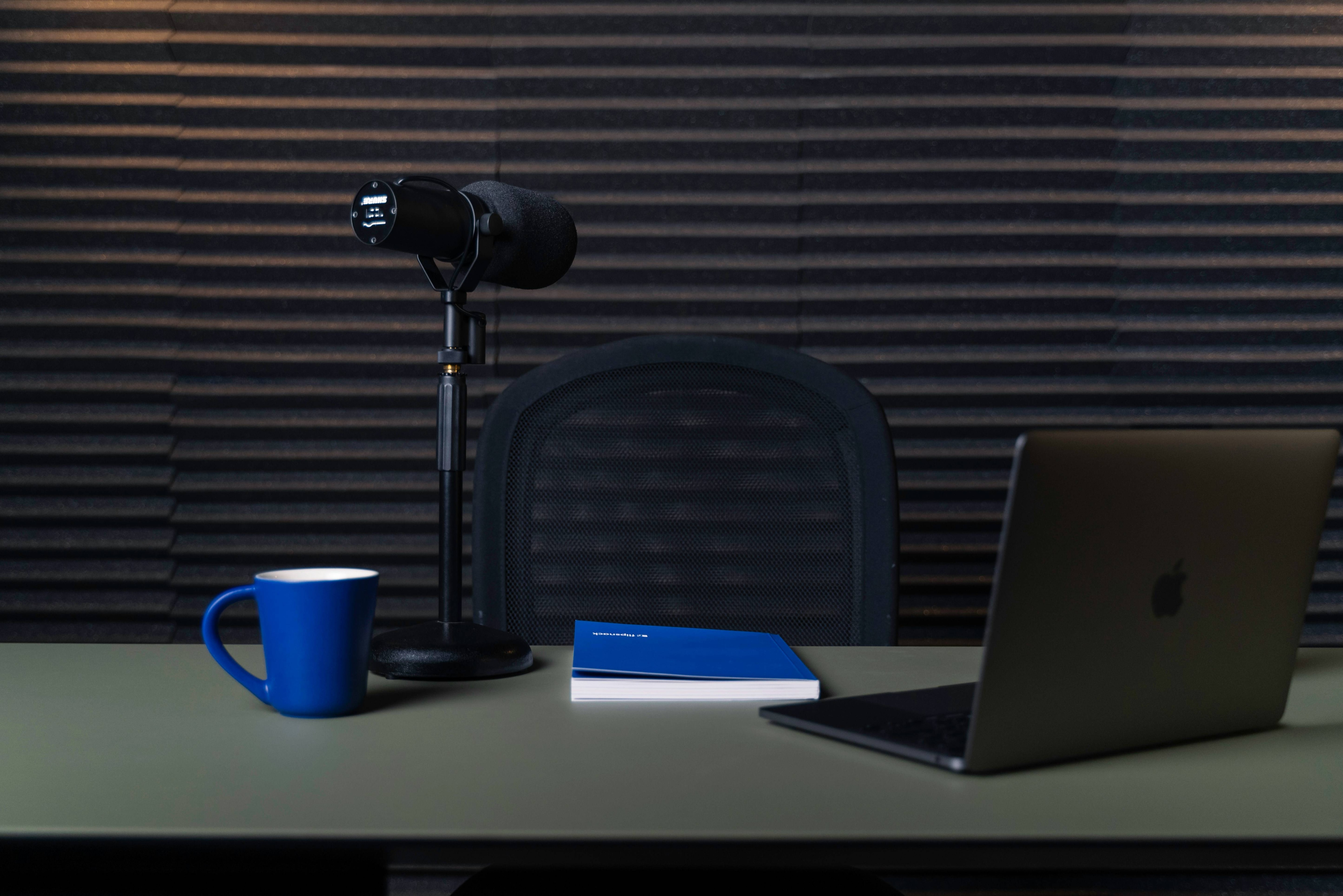 webcam studio with laptop, microphone, and mugs