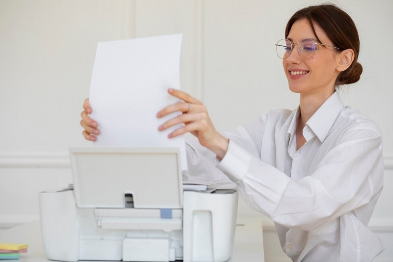 woman placing paper on printer