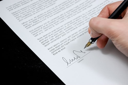 a person physically signing a document 
