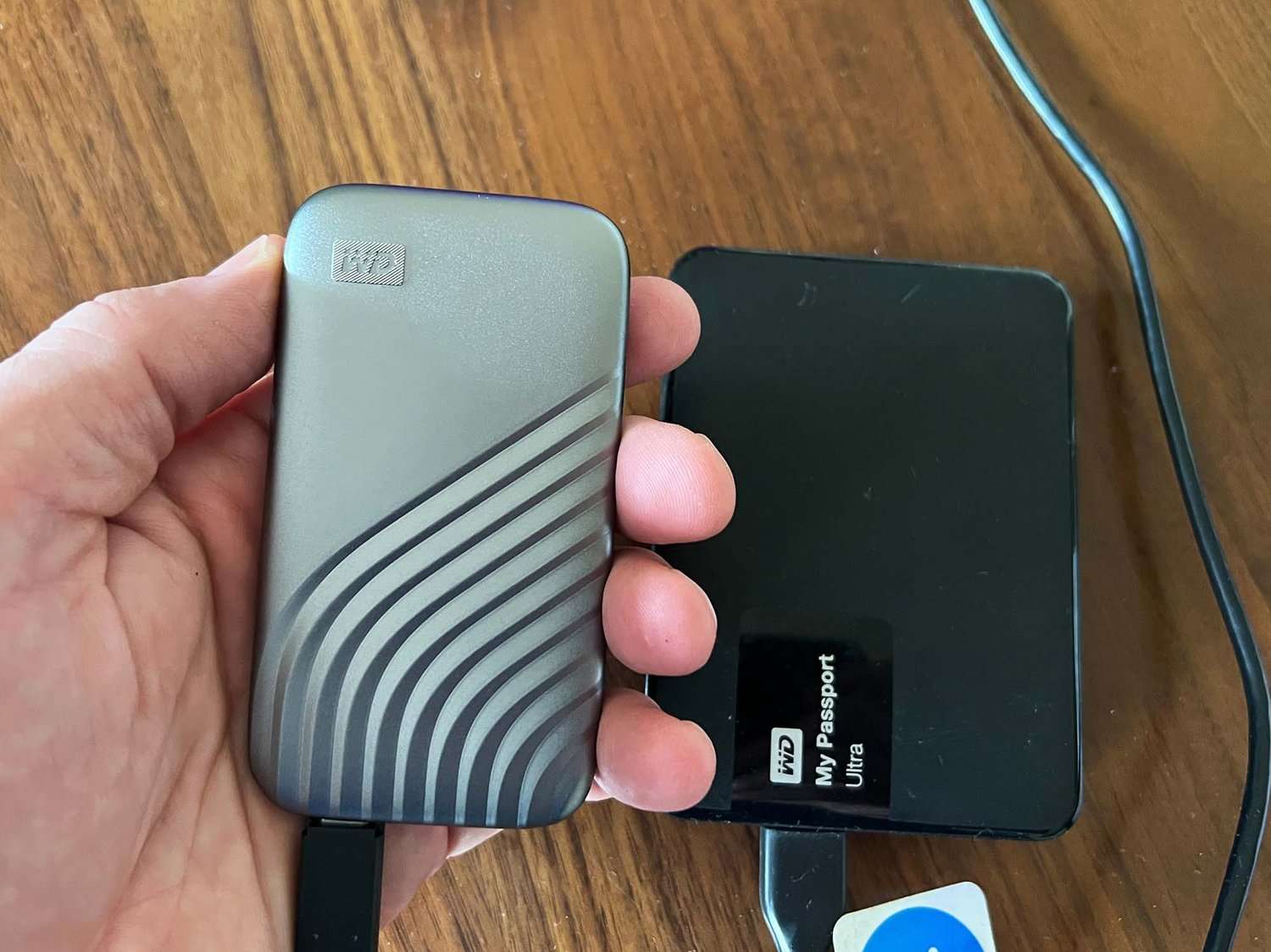 person holding a wd drive with a cable 