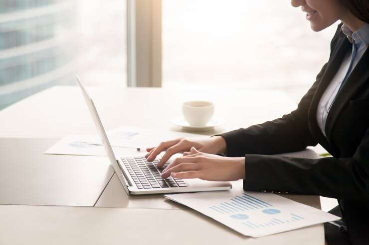 femme travaillant sur des diagrammes et des feuilles de calcul