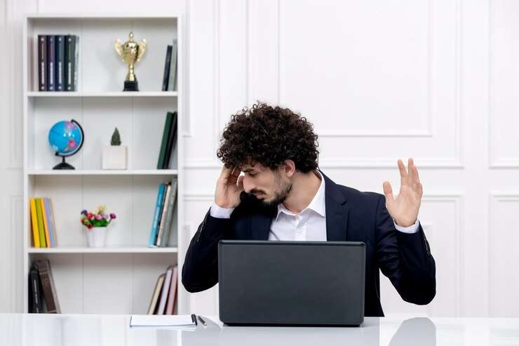 homme agacé devant un ordinateur portable