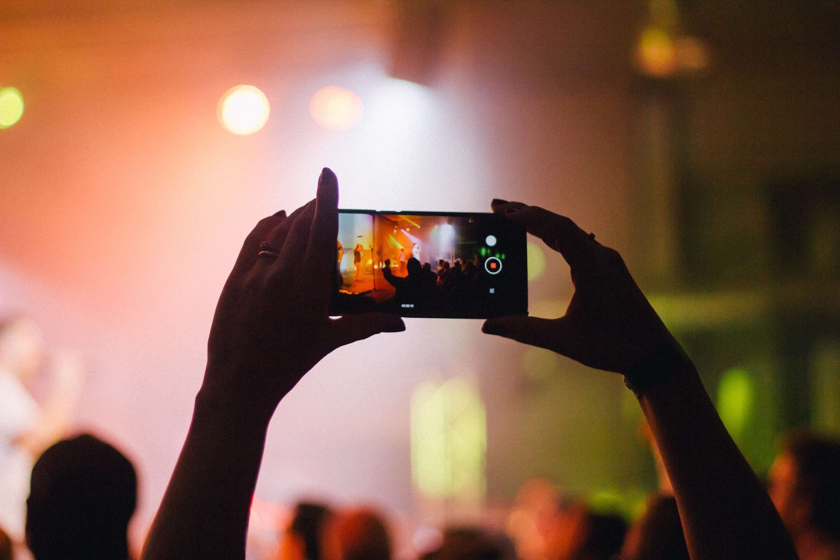 person recording a video of a concert 