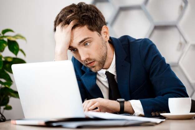 businessman upset in front of laptop