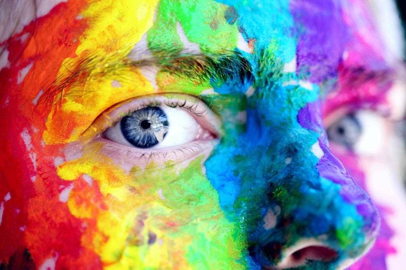 personne avec de la peinture colorée sur le visage 