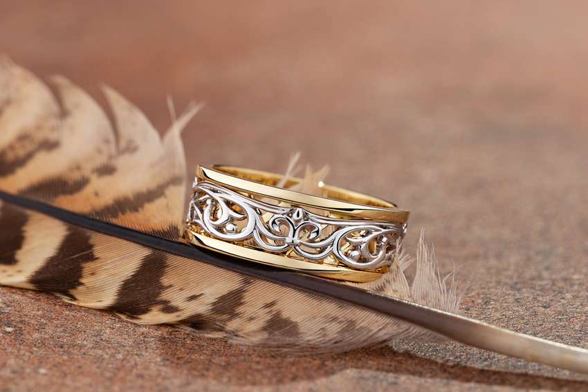 textured white-and-yellow gold ring photography with a barred bird feather